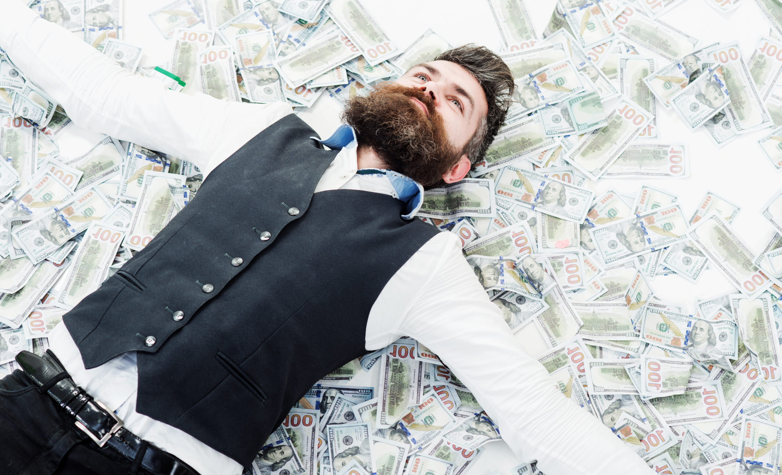 Businessman lying in many banknotes. Saving money. Business success. Rich millionaire, billionaire