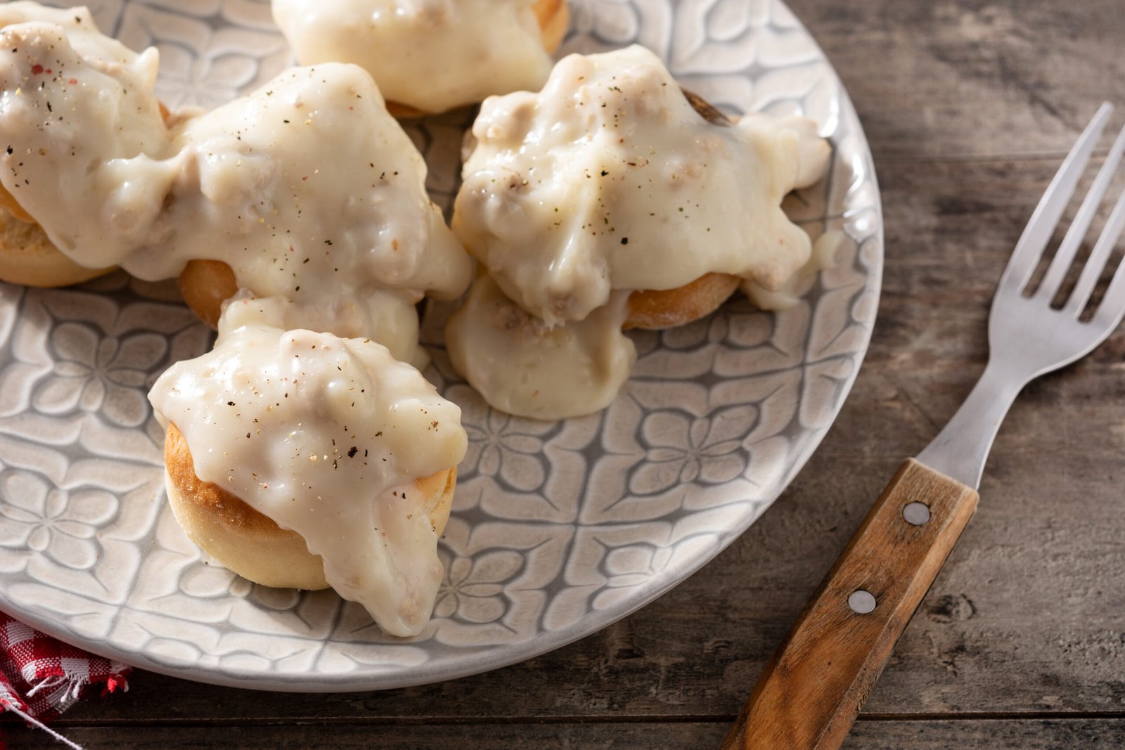 Traditional American biscuits and gravy for breakfast on wooden table