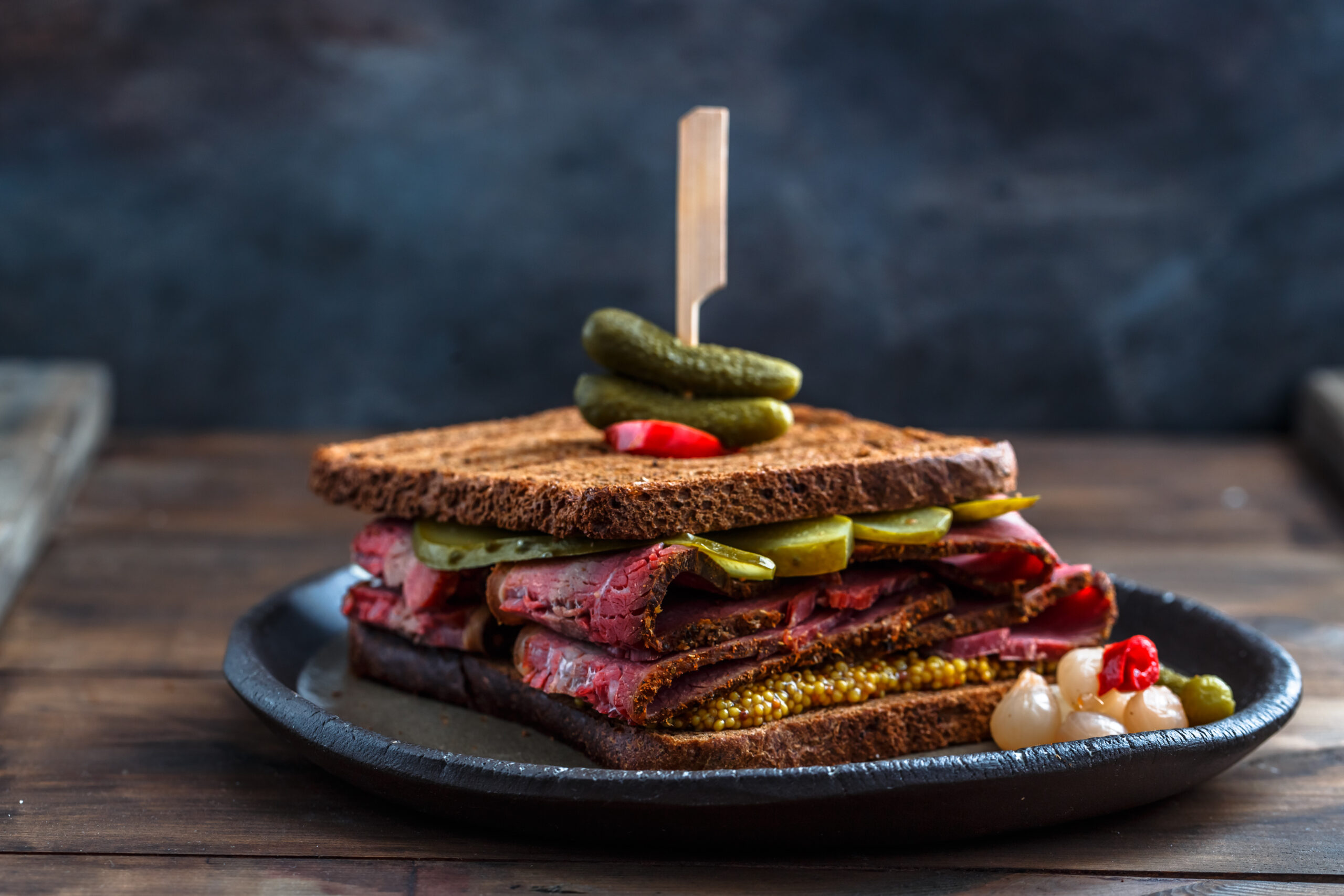 Close view of beef pastrami sandwich on wooden board