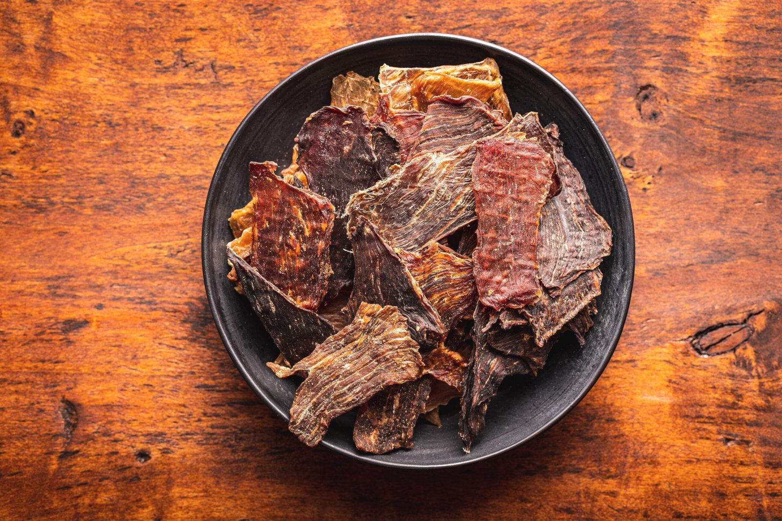 Beef jerky meat. Dried sliced meat in a plate. Top view.